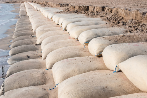 Line big sandbag prevent waves at Cha Am beach of Thailand.