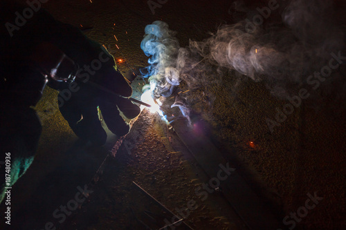 Welder perform welding to the metal plate at roof floor of manufacturing factory by using steel welding electrode in offshore oil and gas industrial operation, Blue collar jobs