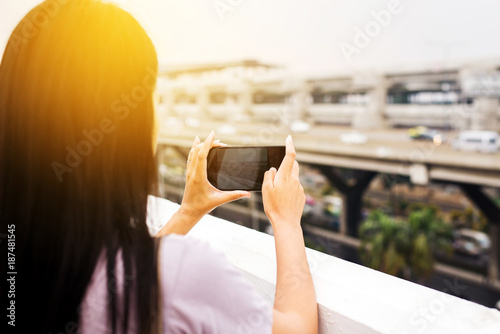 Traveler asian woman taking a photo wiht mobile phone outdoor