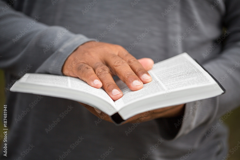 African American man holding a Bible. African American man holding a Bible.