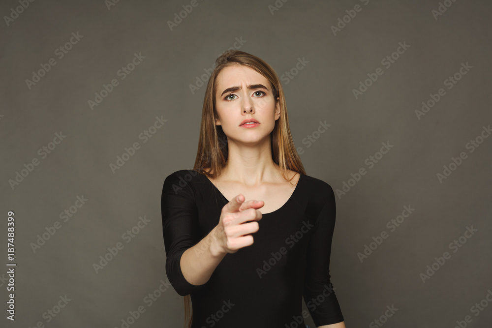 Obraz premium Sad girl pointing finger at camera