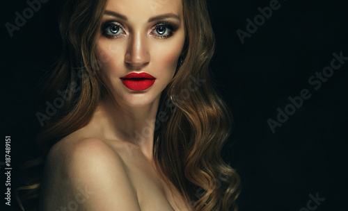 Blonde fashion girl with long and shiny curly hair. Red lips and
