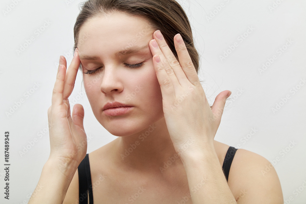 Horizontal headshot of young female model with closed eyes making herself facial massage, softly touching her skin applying gentle pressure. Daily beauty routine concept. Horizontal headshot of young female model with closed eyes making herself facial massage, softly touching her skin applying gentle pressure. Daily beauty routine concept.