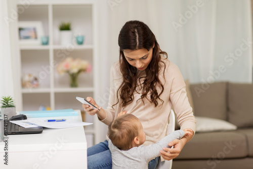 Foto baby boy disturbing mother working at home