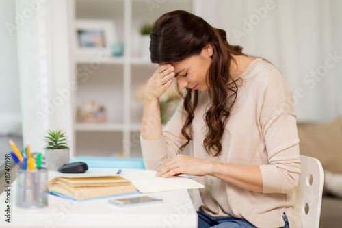 tired female student with book learning at home