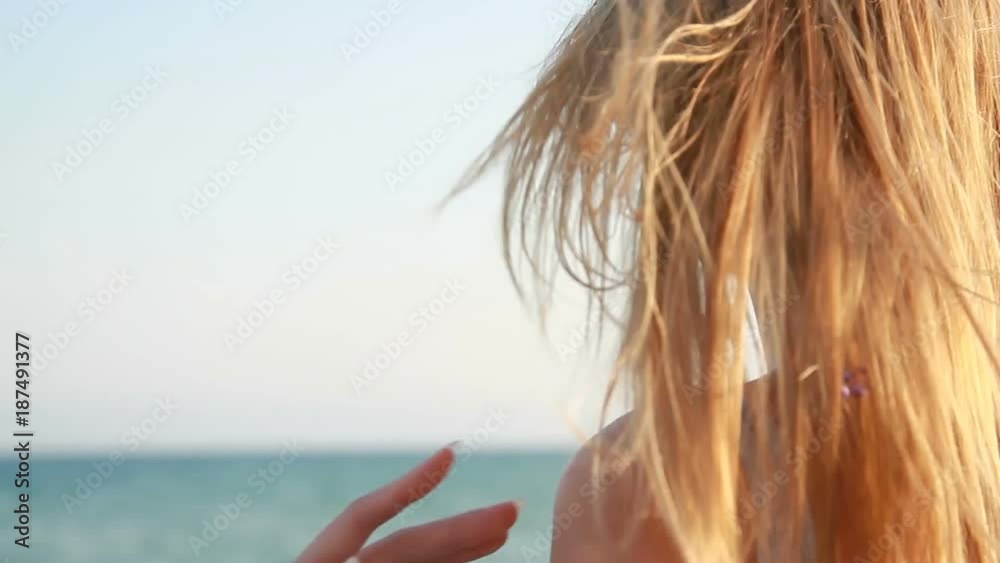 the girl on the beach fixes her hair the girl on the beach fixes her hair