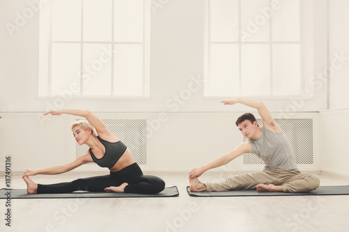 Fitness couple stretching at white background