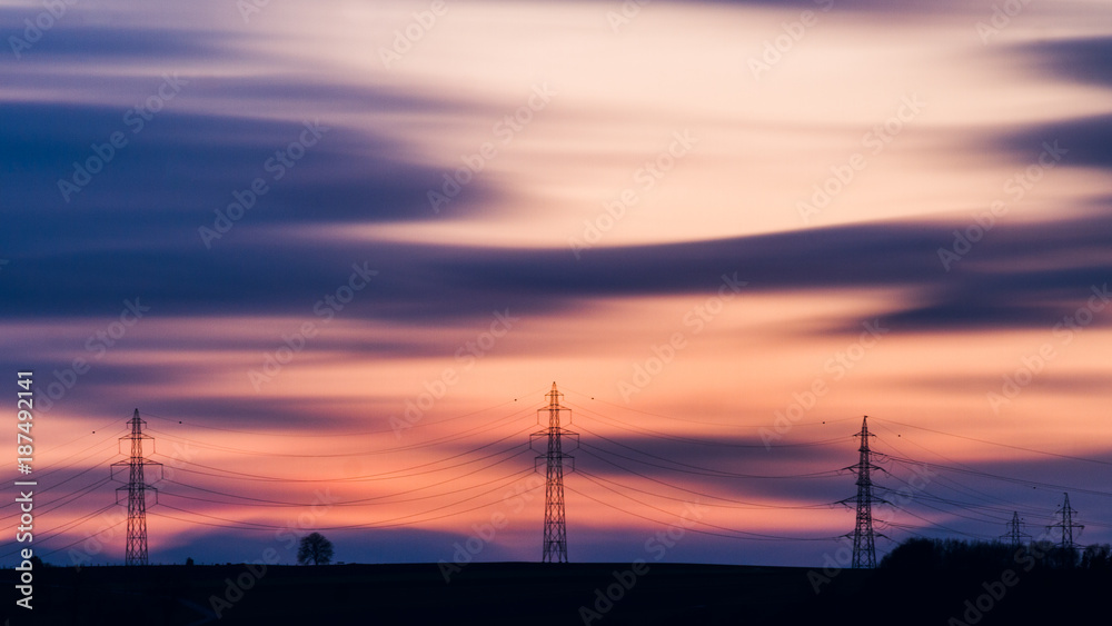 Des pylones électriques au coucher de soleil