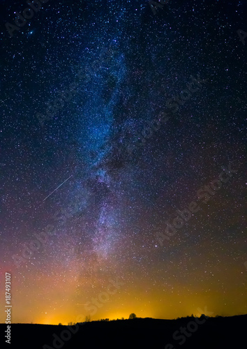 Night landscape image with colorful milky way and yellow light in the horizon