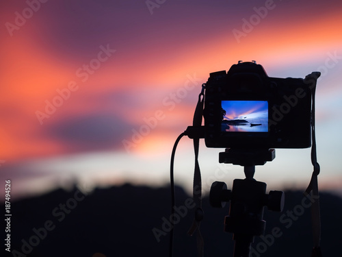 DSLR Camera capturing sunrise of beach view.Close up camera, background Landscape out of focus photo