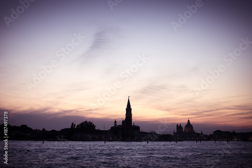 Italian silhouette of Venice sunset, City panorama shot from sea, Italian city panorama vintage shot from sea and sky, Sunset in Venice background, Dark scene of Venice, Symbol of evening Venice