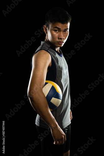 Portrait of an asian professional volleyball player. Isolated on black background