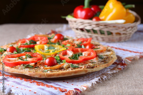 Cooked pizza, vegetables and ingredients are on the table.