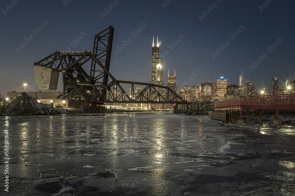 Sheets of ice on river moving toward Chicago skyline with raised train bridge