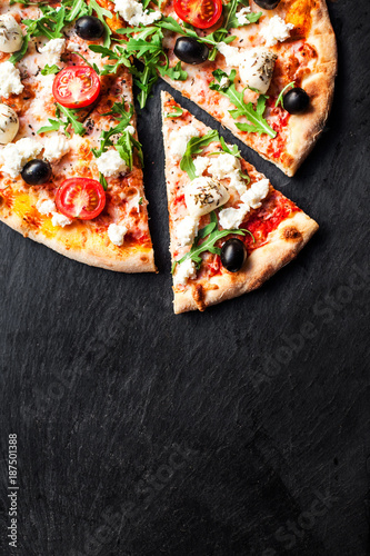 Hot pizza slice with melted mozzarella cheese and tomato on black concrete background.  Pizza Ready to Eat, Copyspace..