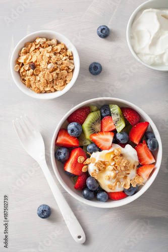 fruit berry salad with yogurt and granola for healthy breakfast