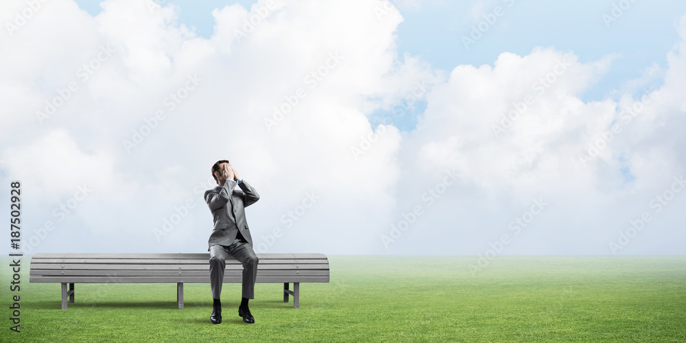Young man in summer park on bench do not want to see anything Young man in summer park on bench do not want to see anything