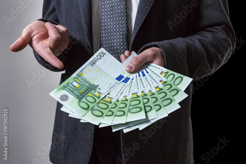 A Thousand Euros. A Man offering 100 euro banknotes.