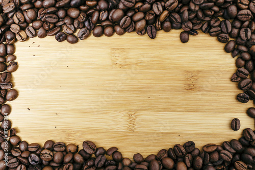 Brown coffee beans frame on a wooden board background