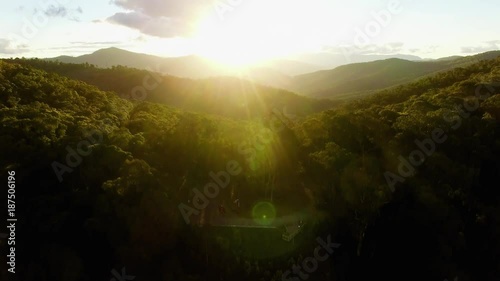 Beautiful aerial rise above Australian alps at sunset wiht sun flare photo