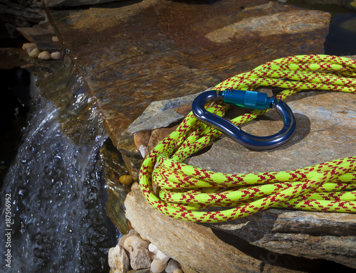 Carabiner and climbing rope next to water photo