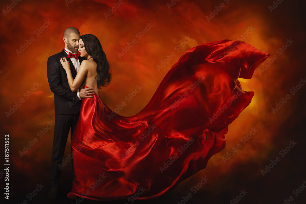 Fototapeta Elegant Couple, Dancing Woman in Red Dress Fluttering Flying on wind and Man in Black Suit, Love Beauty Portrait