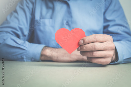 Businessman showing red heart.