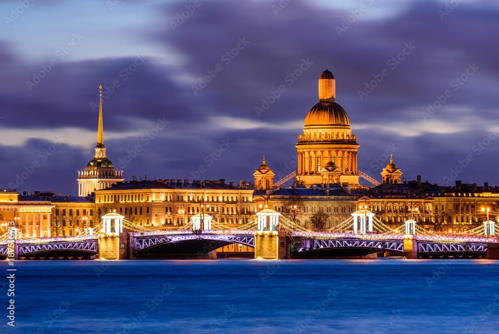 Evening View of the city decorated with lights. View of the main attractions - the Palace Bridge and St. Isaac Cathedral. Russia, Saint-Petersburg.