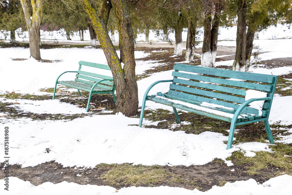 Green bench in the park in winter. Snow in the park. Green bench in the park in winter. Snow in the park.