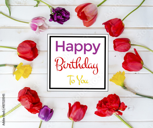 Happy Birthday Greeting Card with Tulips Frame on a White Wooden Background