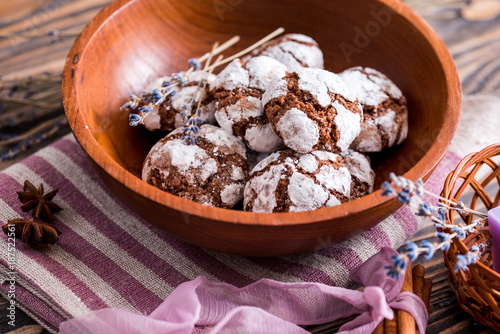 Cheese cookies with herbs. Morning breakfast. On a wooden plate on a dark textured wooden background. Lavender and cardamom, cinnamon sticks on a purple napkin with ribbon photo