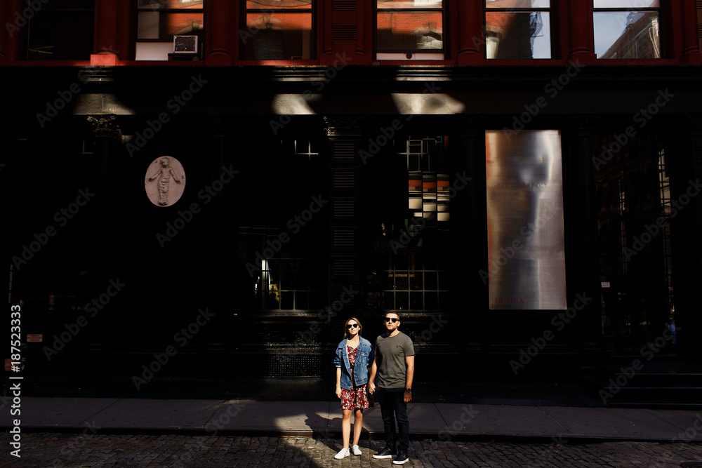 Lovely young couple dressed in casual style walks around Soho and New York city in morning lights