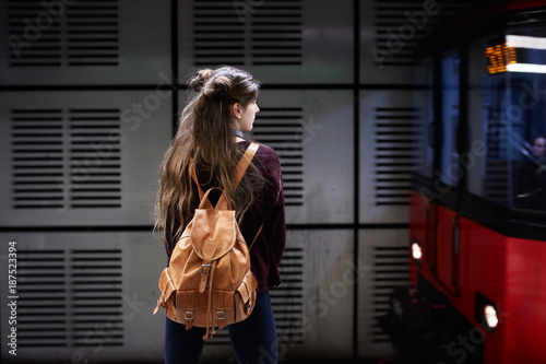 Young woman with bagpack waiting for the subway photo