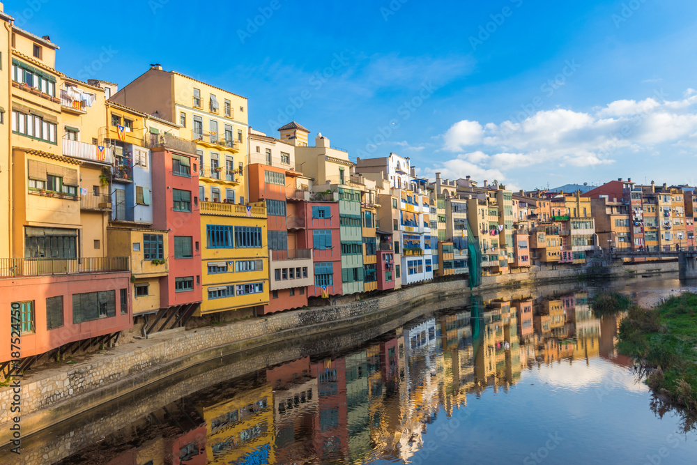Colorful river-front houses lining the Onyar river, mostly built on top of old medieval defense walls, Girona, Catalonia, Spain