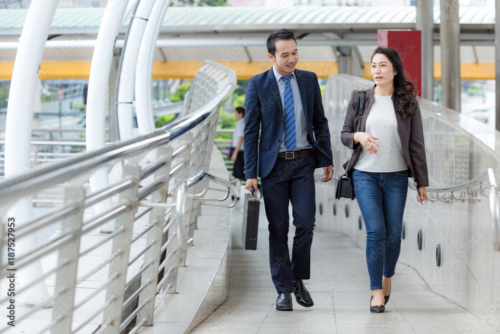 Fototapeta premium Businessman walking with workmate when finish working.