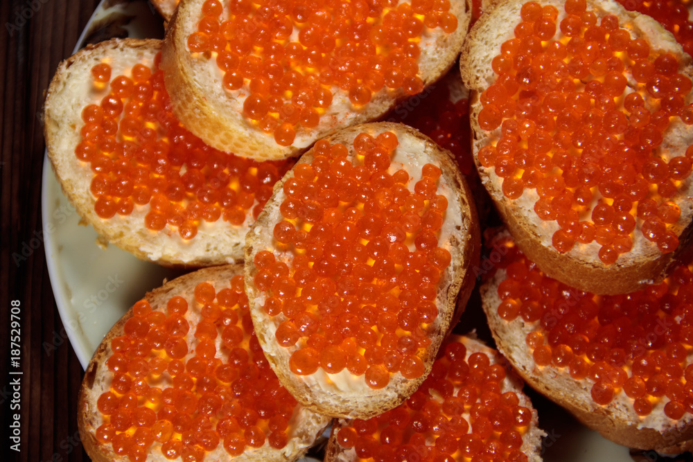 Sandwiches with butter and red caviar on wooden table Sandwiches with butter and red caviar on wooden table