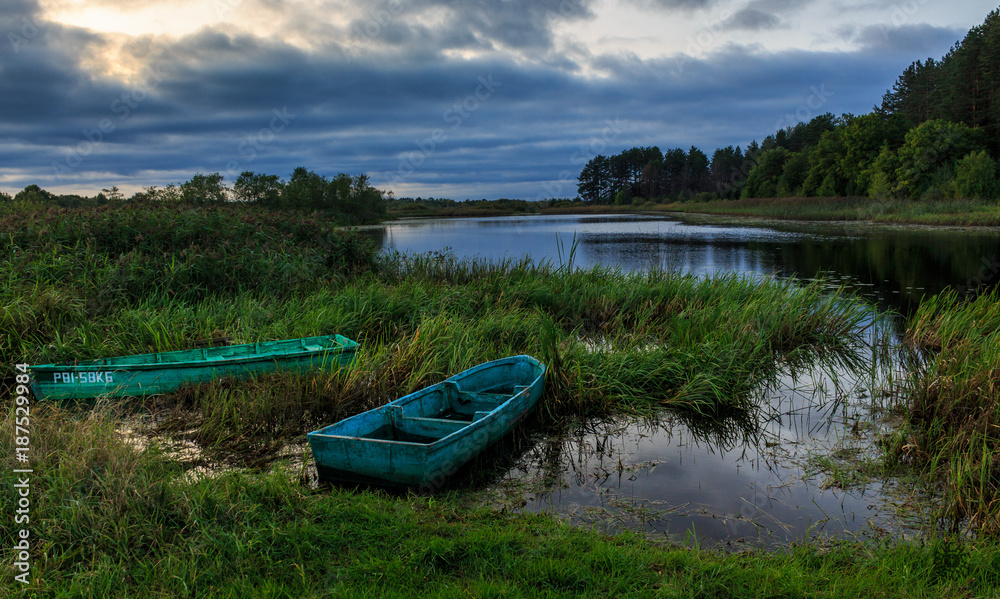 Obraz premium Decline against the background of boats and the forest lake