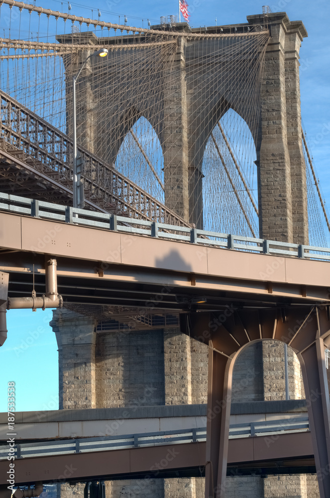 Fototapeta premium Fragment neogotyckich łuków i stalowych lin wiszących Brooklyn Bridge, arcydzieło inżynierii lądowej, Nowy Jork