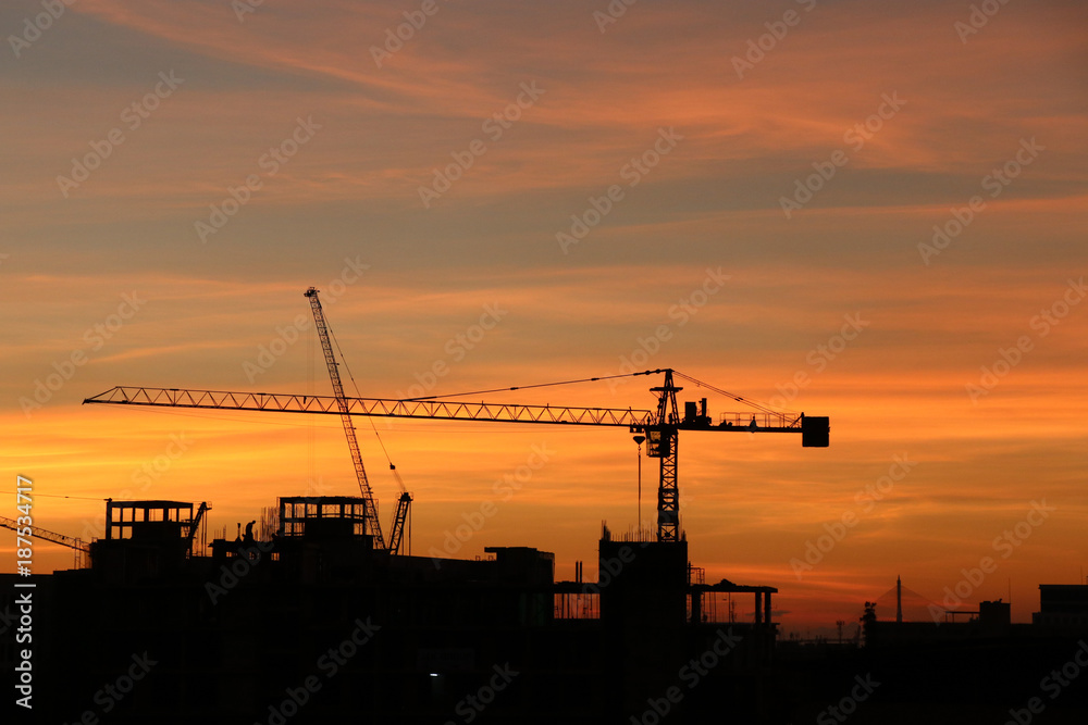 Silhouette crane and building construction sunset background gold sky color in the evening time
