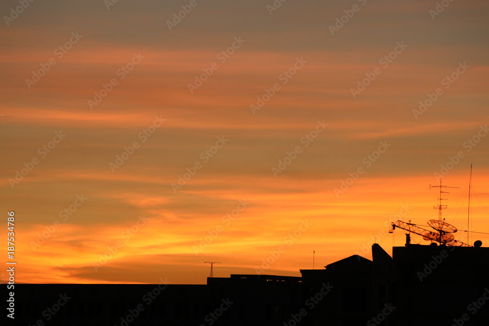 Silhouette and stanchion on roof houses  sunset time sky gold color in the evening