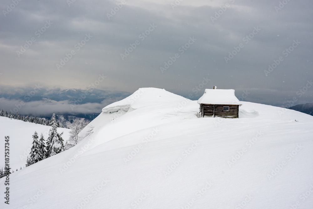 Shelter for tourists in the snowy mountains. Wooden hut over the mountain valley. Active rest in the winter in the Carpathians.