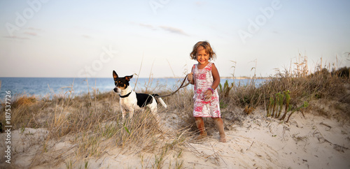 little girl with a dog on the beach