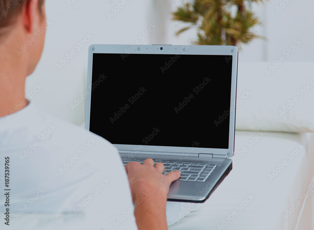 Rear view closeup of a young man working of a laptop.