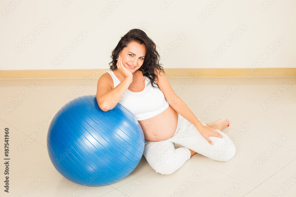 Naklejka premium Young brunette pregnant woman with blue powerball