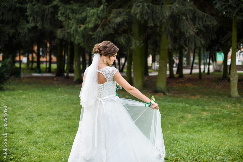 Handsome gorgeous bride in white wedding dress with bridal bouquet