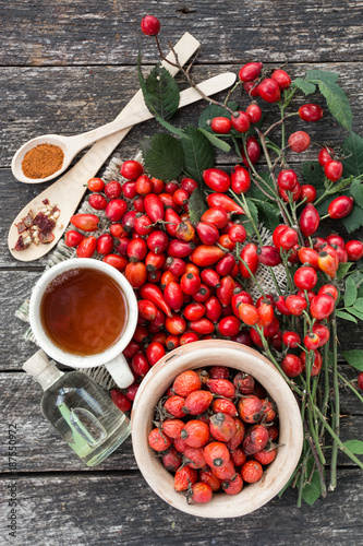 Tableau sur toile cup of herbal Dog rose tea with bunch branch Rosehips, types Rosa canina hips, essential oil