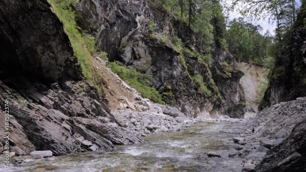 Beautiful water in a mountain river in slow motion video. Shooting speed 60fps, slow motion. Live shooting of the most beautiful nature river mountain water. The camera is not static.