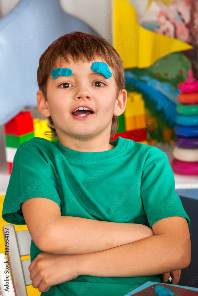 Child dough play in school. Plasticine for children. Mold from plasticine in kindergarten. Boy fun and makes faces in kindergarten. Student does not listen to teacher. Child dough play in school. Plasticine for children. Mold from plasticine in kindergarten. Boy fun and makes faces in kindergarten. Student does not listen to teacher.