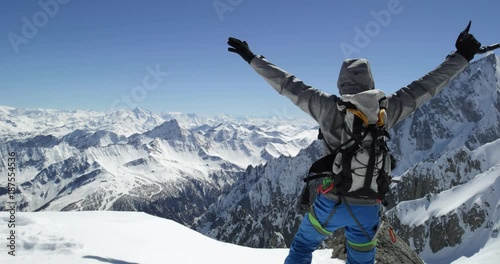 Climber mountaineer man reaching snowy mount top success in sunny day.Mountaineering ski activity. Skier people winter snow sport in alpine mountain outdoor.Back view.Slow motion 60p 4k video