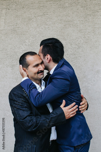 A father and son hug each other with love and pride.